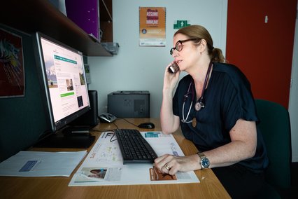 Dr Ros Wall on computer at practice